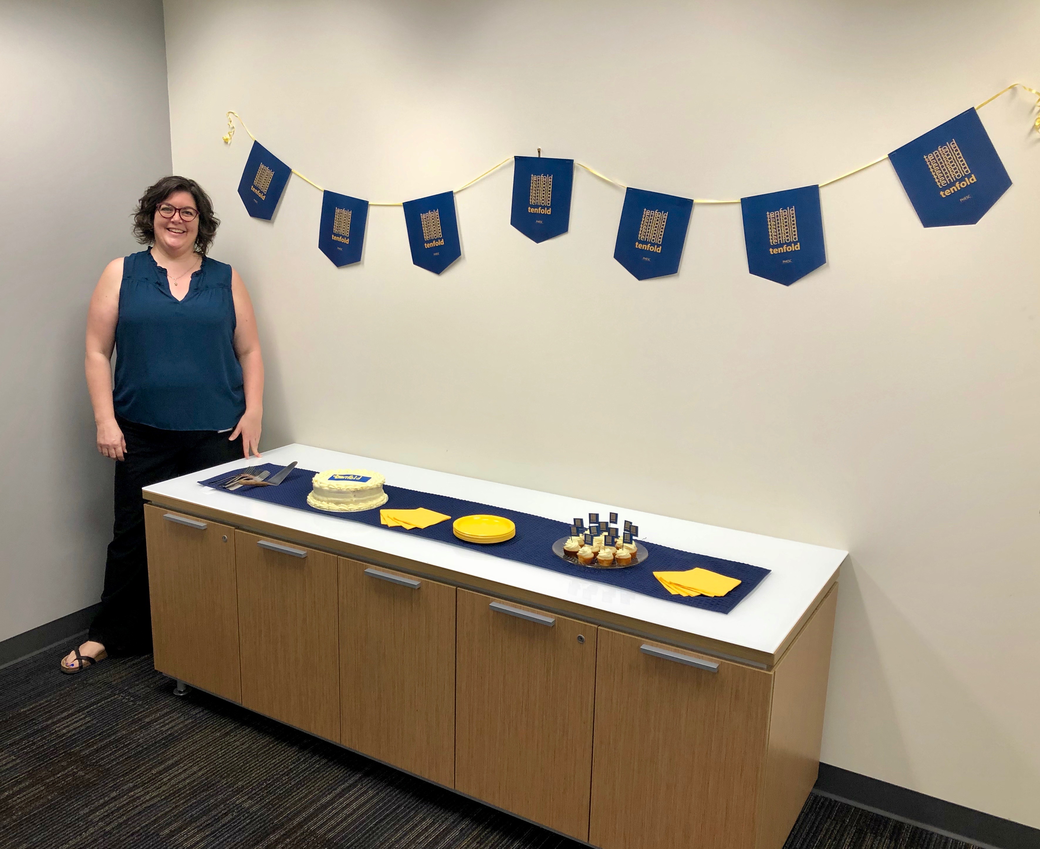 Host Andrea Bodkin with cupcakes and cake to celebrate the launch of Tenfold!